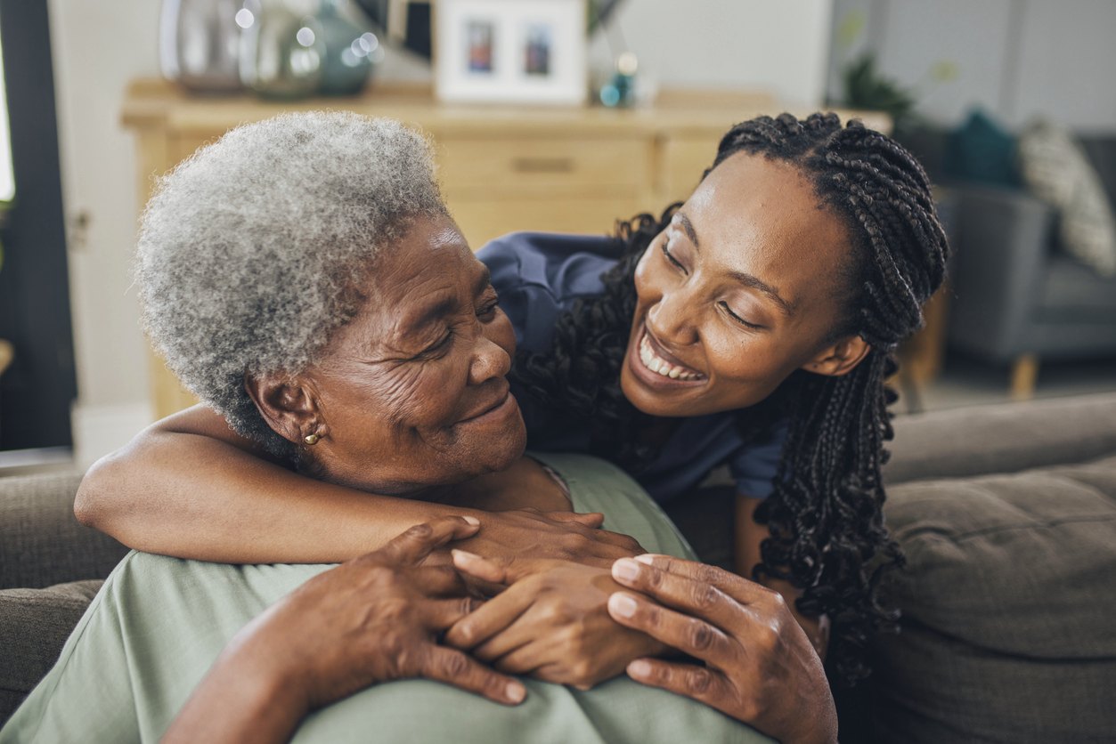 Care professional comforting a senior woman at home during a senior living transition in Atlanta